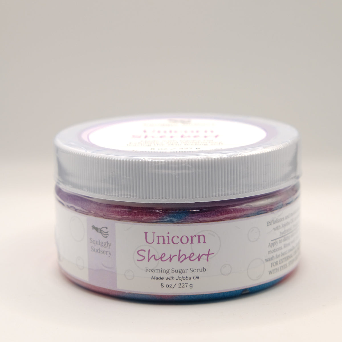 Jar of Unicorn Sherbert foaming sugar scrub with a white lid on a light gray background