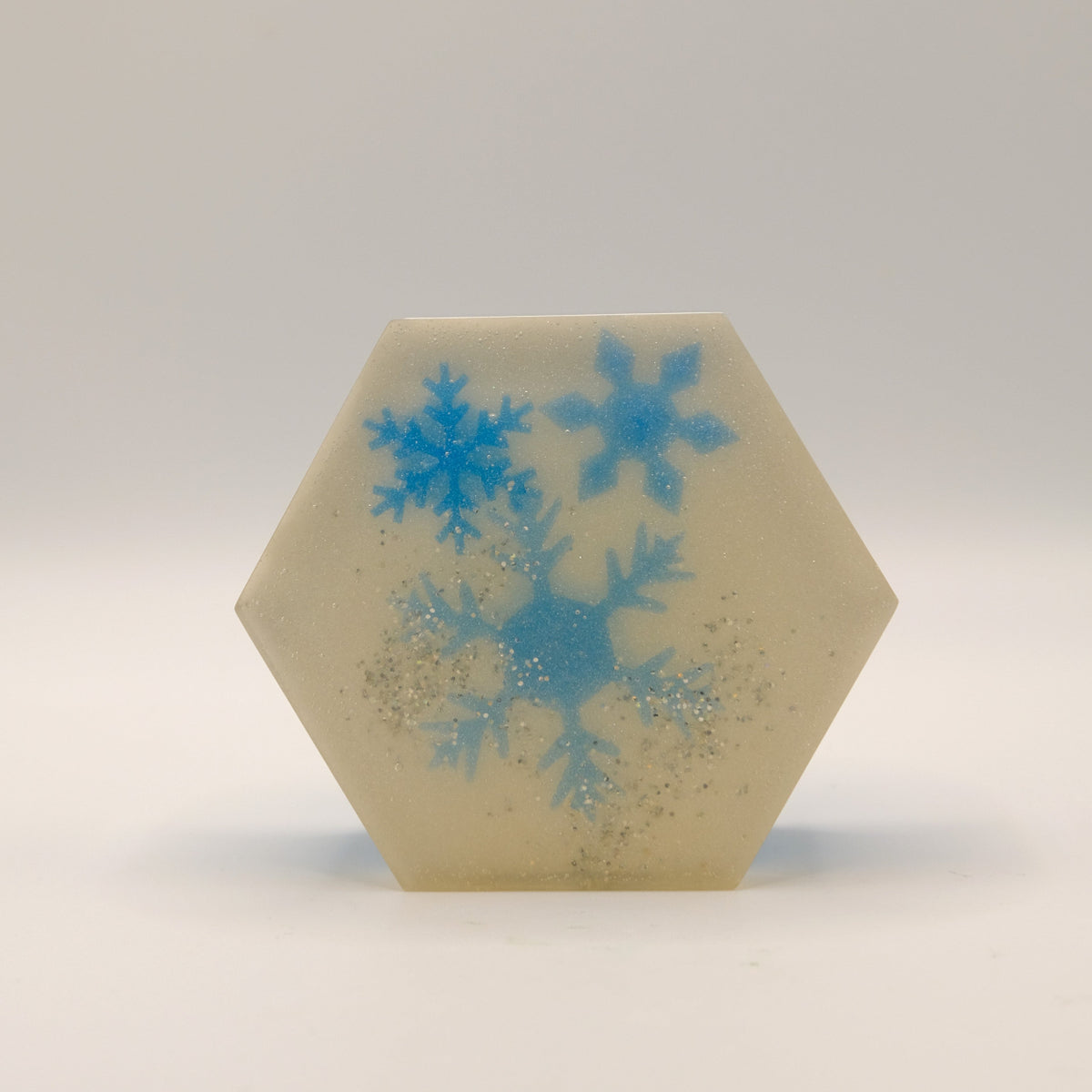 Hexagonal soap bar with blue snowflake design on a white background