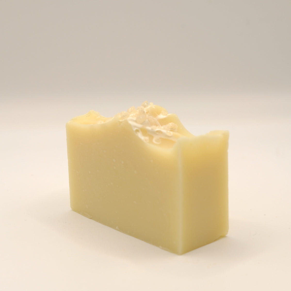 Bar of soap with a textured top on a light gray background